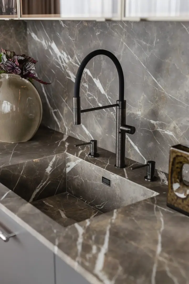 Detal kuchni z marmurowym blatem i czarną baterią – fotografia wnętrz apartamentu w Krakowie