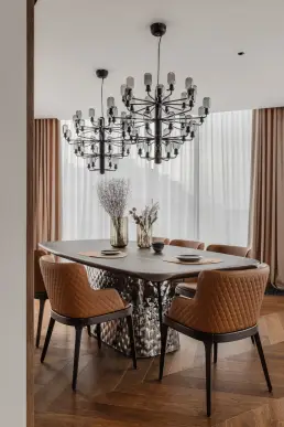 Jadalnia z owalnymi tapicerowanymi krzesłami i designerską lampą sufitową – fotograf wnętrz, apartament Kraków