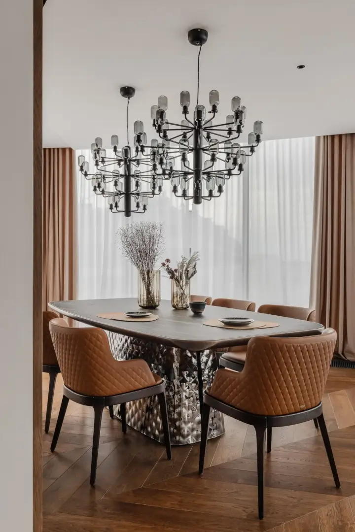 Jadalnia z owalnymi tapicerowanymi krzesłami i designerską lampą sufitową – fotograf wnętrz, apartament Kraków