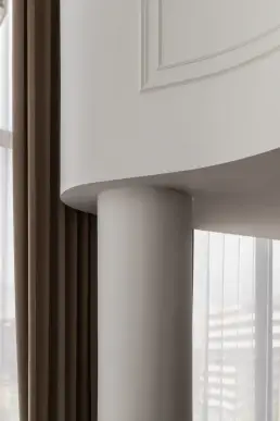 Zaokrąglona kolumna nośna i gzyms sufitowy w salonie – zdjęcia wnętrz, detal architektoniczny apartamentu w Krakowie