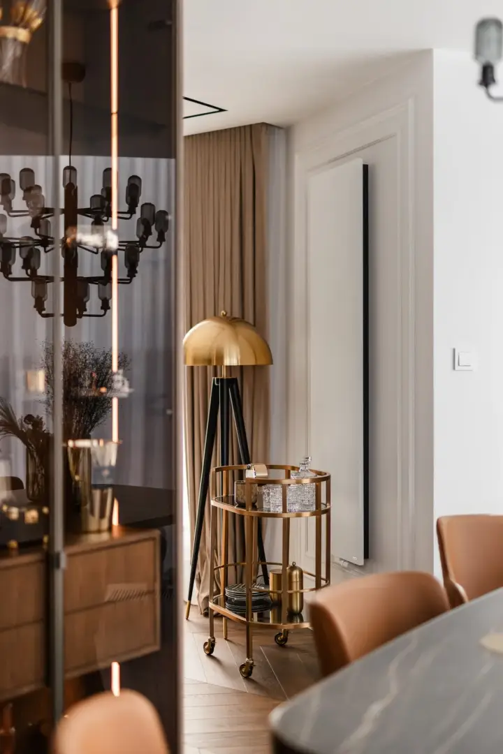 Złoty wózek barowy i lampa kloszowa przy jadalni – sesja fotograficzna wnętrz apartamentu w Krakowie