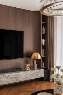 Zabudowa TV z forniru dębowego ze złotymi listwami i lampą kloszową – zdjęcia wnętrz apartamentu