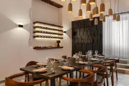 restauracja Muro Rzeszów — sala prywatna z podświetlanym regałem na wino, ścianą z drewnianych bloków i ceramicznymi lampami
