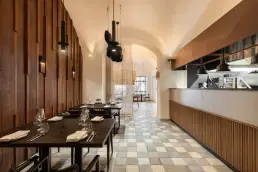 restauracja Muro Rzeszów — sala główna z drewnianymi lamelami na ścianie, otwartą kuchnią i rzeźbą wiszącą pod sklepieniem