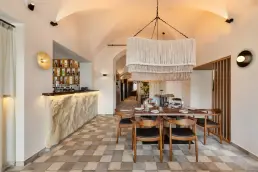 restauracja Muro Rzeszów — bar z kamiennym frontem i półkami z alkoholami pod sklepieniem, makramowa lampa i stolik