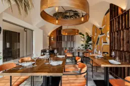 restauracja Muro Rzeszów — panorama sali z okrągłymi lampami, ręcznie malowanym muralem, monstrerą i pomarańczowymi krzesłami