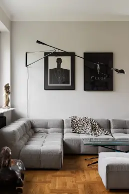 Salon z szarą modułową sofą, grafikami i rzeźbą na parapecie – fotograf wnętrz, mieszkanie w WarszawieSalon z szarą modułową sofą, grafikami i rzeźbą na parapecie
