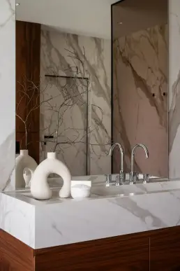 Detal kompozycji łazienkowej z ceramicznymi wazonami w organicznych formach na marmurowym blacie umywalki