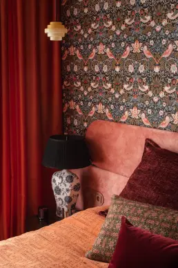 detal sypialni z porcelanową lampą, tapetą Morrisa i kaskadowym kinkietem