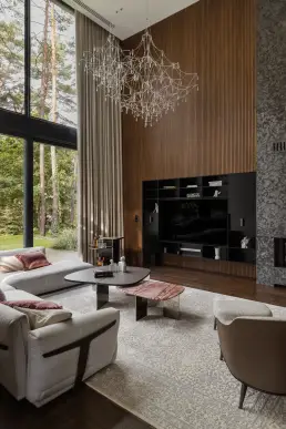 Salon z dwukondygnacyjnym oknem i designerskim żyrandolem – fotografia wnętrz nowoczesnej rezydencji w Józefowie