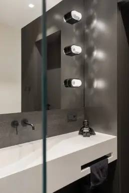 Detal łazienki z czarną armaturą i industrialnymi kinkietami przy lustrze – fotograf wnętrz, projekt Józefów